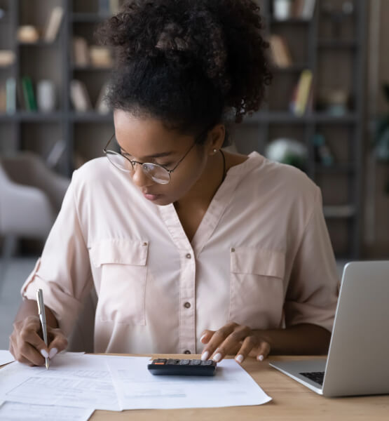 Lady sitting at her desk with laptop and calculator budgeing