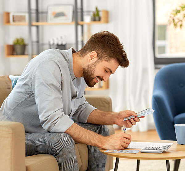 Man calculating expenses and writing them down. 