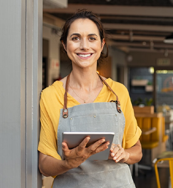 Business woman holding tablet standing outside of shop