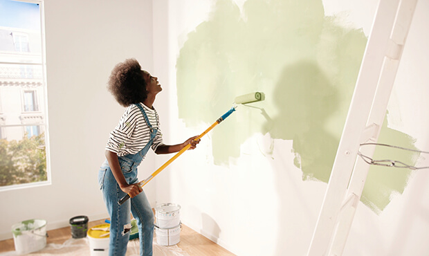 Women painting the walls light green. 