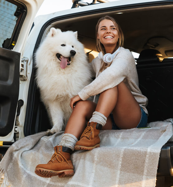 Lady sitting in the car with her dog 