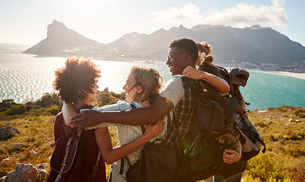 Friends hiking with mountain view in background. 