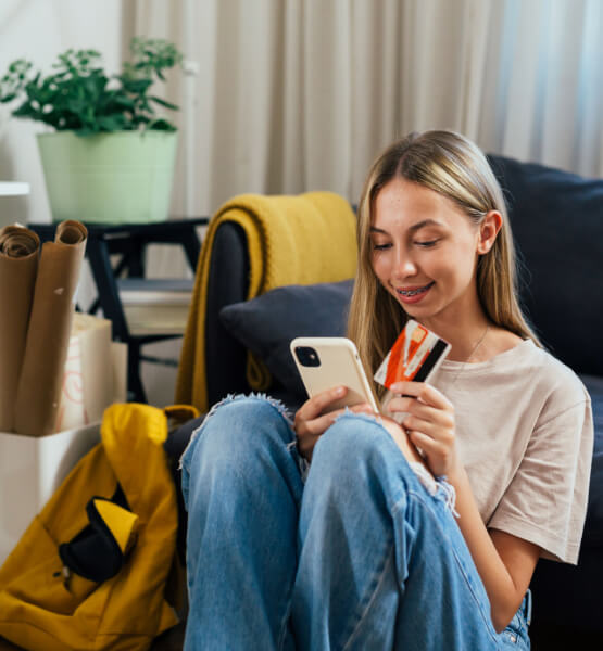 Teenager using digital banking and holding debit card.