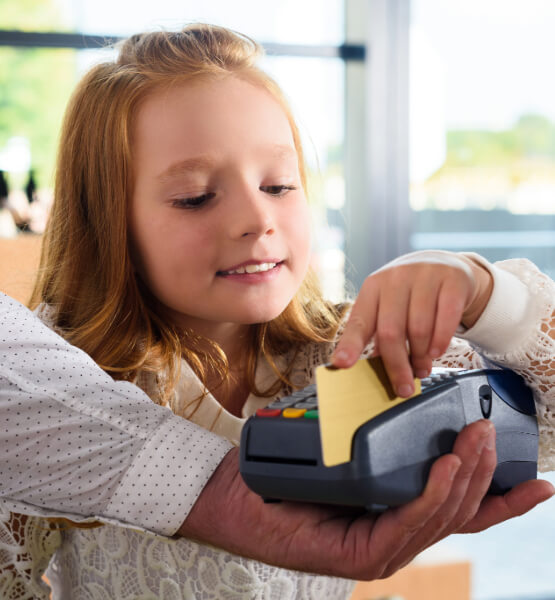 Kid holding swiping a credit card on a POS card machine. 